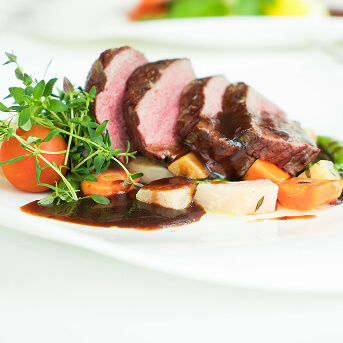 Sliced Beef Tenderloin Served with Vegetables and Herb Garnish at Memory Care Facility Sliced Beef Tenderloin Served with Vegetables and Herb Garnish at Memory Care Facility