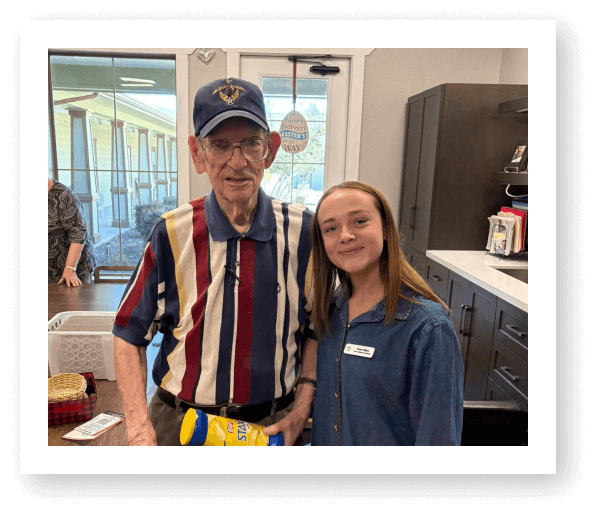Elderly Man Standing with Young Volunteer in Kitchen at Assisted Living Facility
