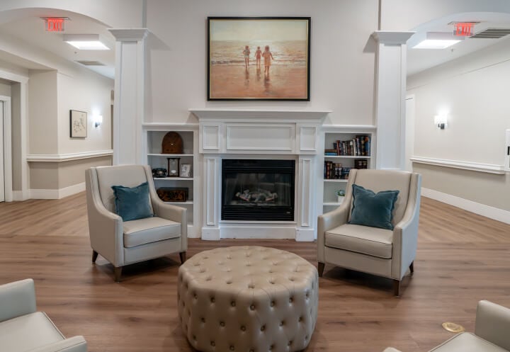 Fireplace Lounge with Tufted Ottoman for Seniors at Memory Care Facility Fireplace Lounge with Tufted Ottoman for Seniors at Memory Care Facility