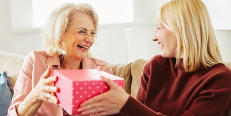 Granddaughter Giving Gift to Elderly Woman at Memory Care Facility
